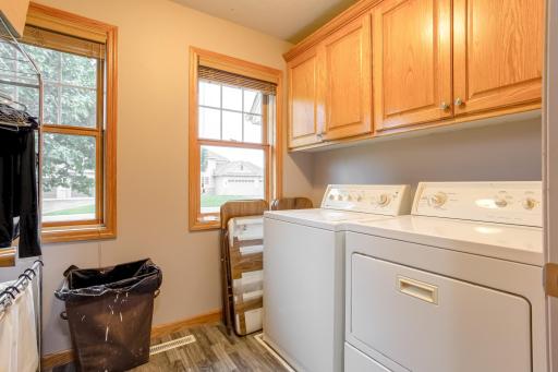 Dedicated laundry room with storage cabinetry and natural light adds everyday convenience.