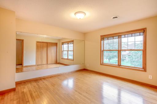 Sunny bedroom offers hardwood flooring, large windows, and a comfortable layout perfect for family or guests.