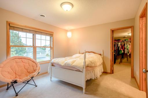 Comfortable upper-level junior suite features large windows, soft natural light, and a large walk-in closet.
