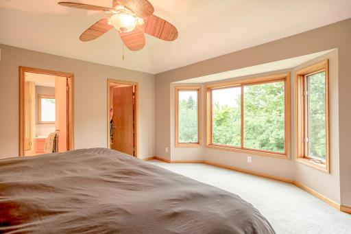 Enjoy serene treetop views and abundant natural light from the oversized bay window in the primary suite.