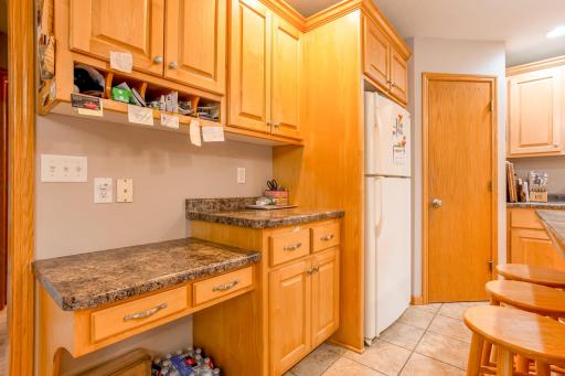 Convenient built-in desk area and abundant cabinetry provide the perfect blend of organization and functionality.