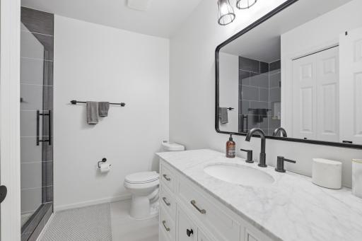 Lower level 3/4 bathroom with updated ceramic shower, vanity and flooring!