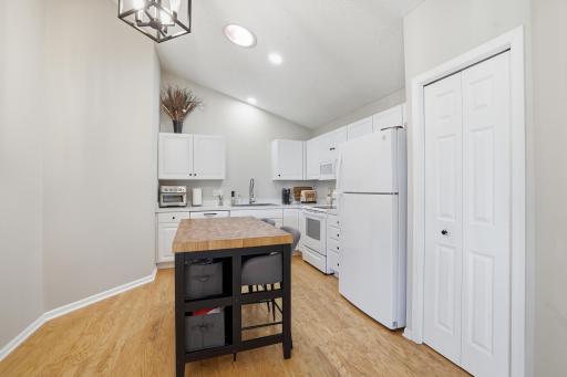 The kitchen has hardwood flooring and ample cabinet space and pantry