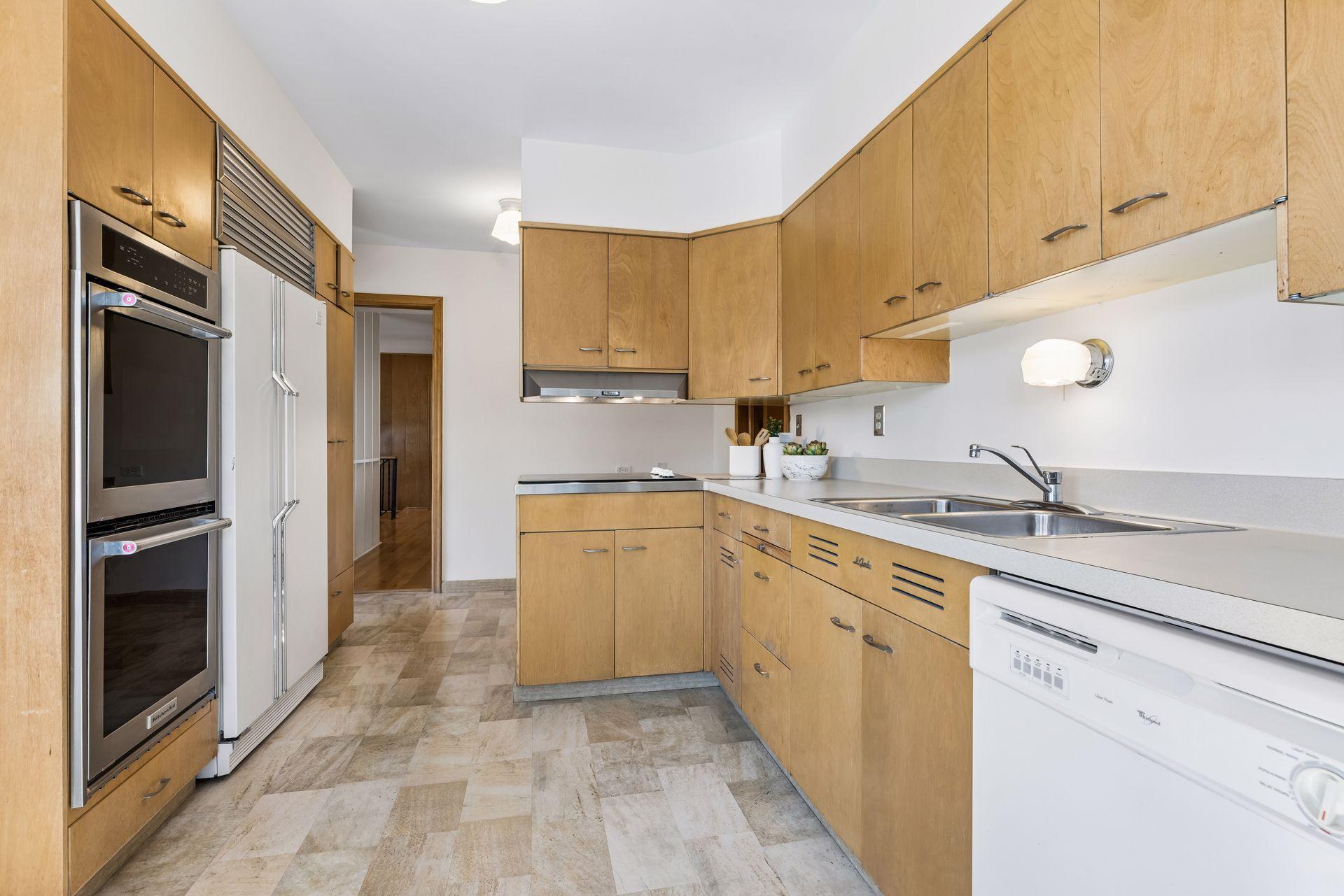 The kitchen has a double wall oven, gas cooktop with hood fan and plentiful storage and counter space.