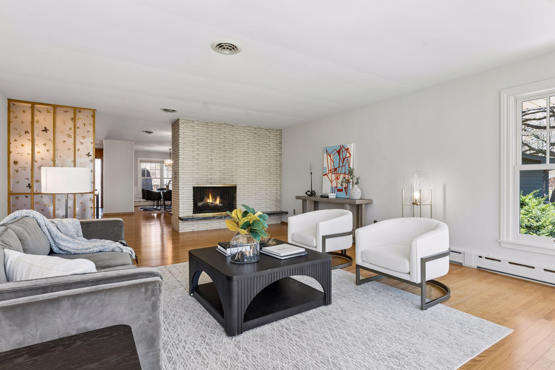 The main floor living room offers beautiful mid-century details including a cozy floor-to-ceiling brick fireplace and beautiful period screen wall.