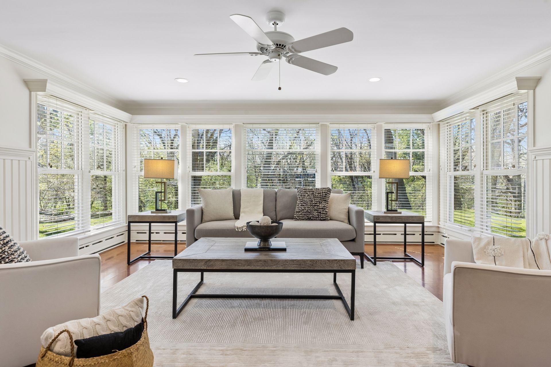 The sunroom offers solid surface flooring, custom blinds, overhead lighting and even a breezy ceiling fan.