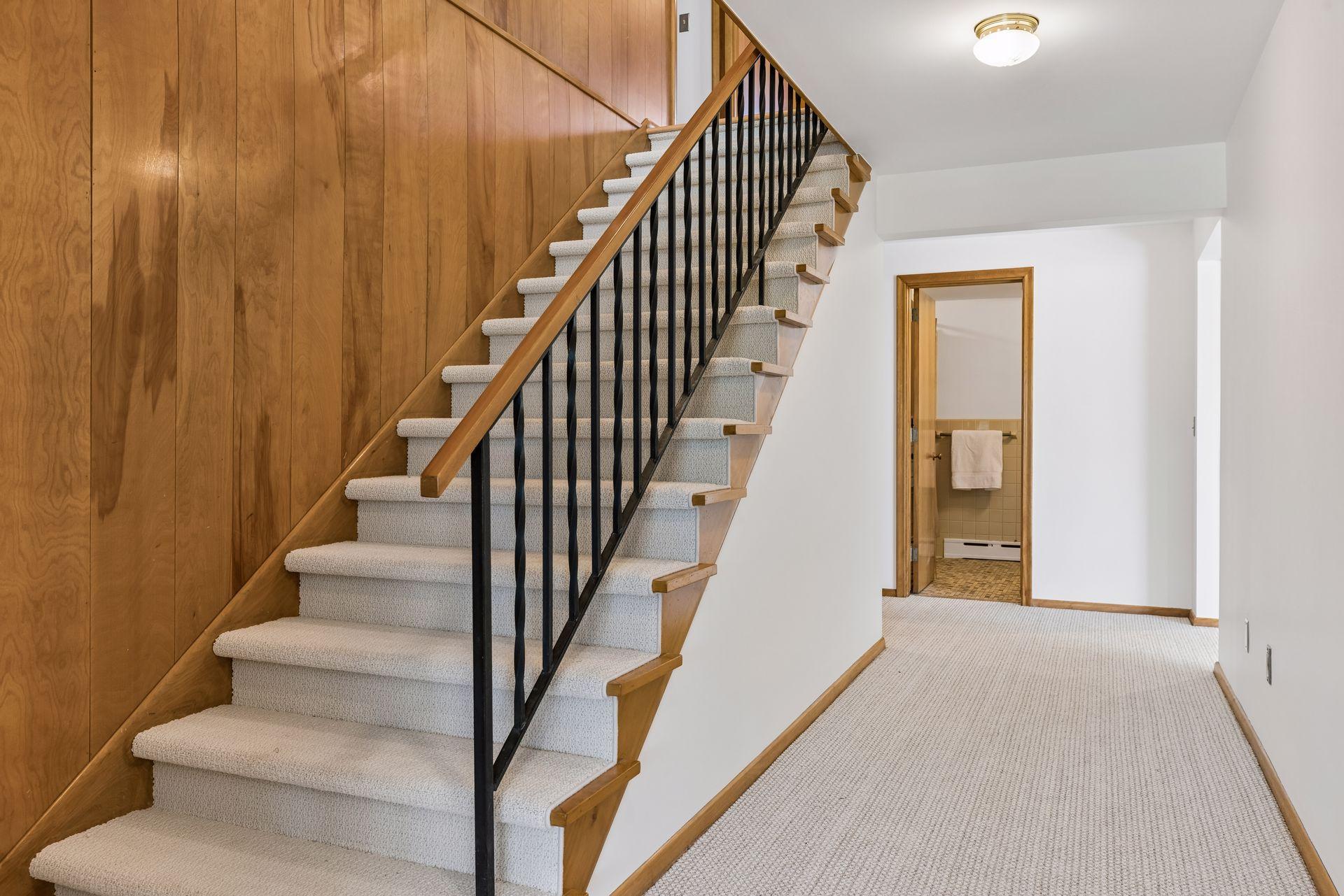 The gorgeous rich wood paneling continues down the stairway to the walkout level. Newer berber carpet and fresh paint offer you a neutral backdrop to customize your spaces.
