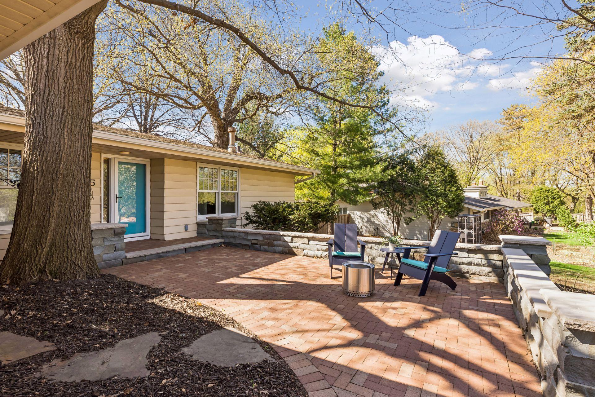 The front paver patio with natural stone knee-walls makes a great first impression to this delightful home.