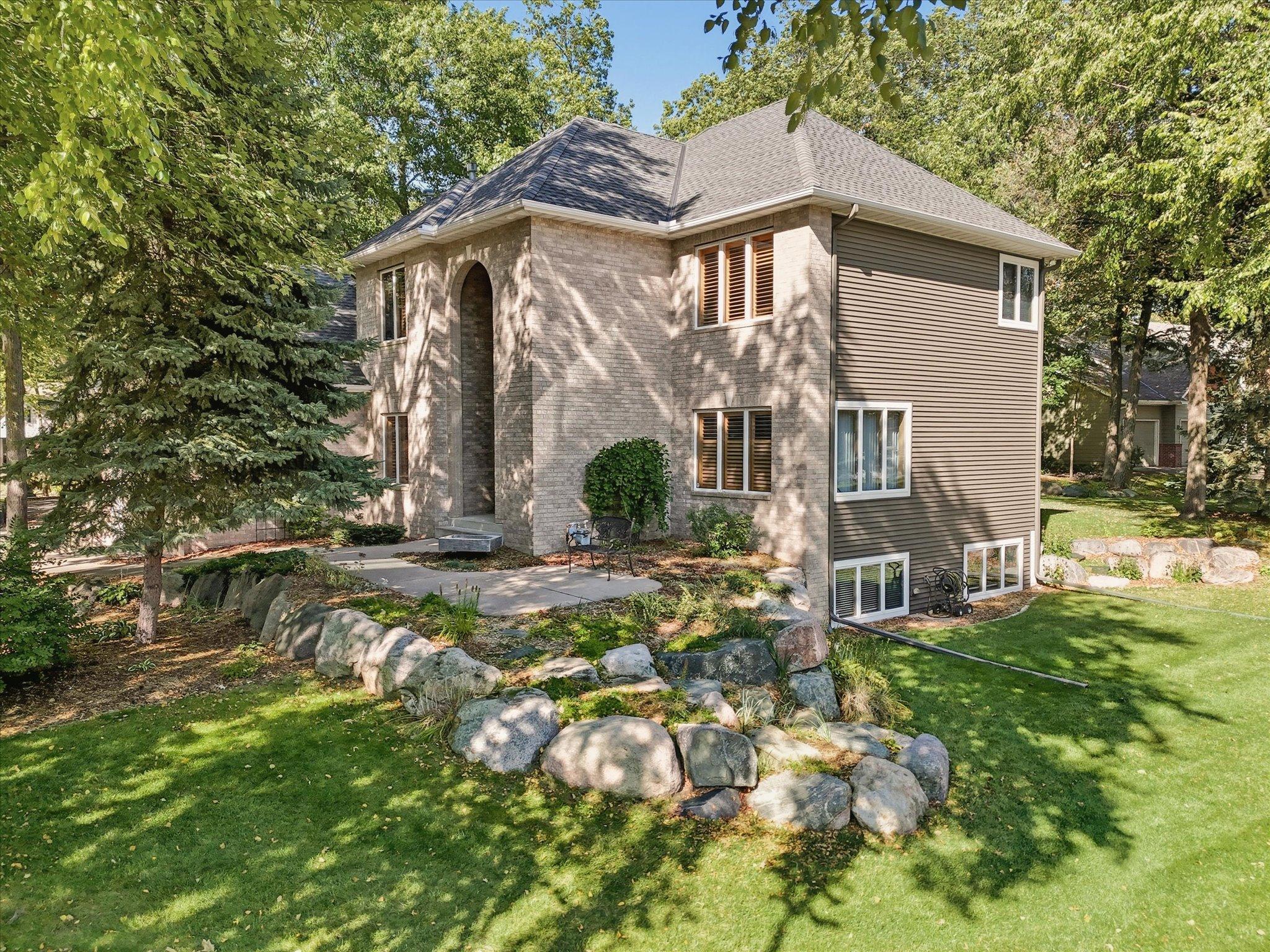 Beautiful landscaping includes: three landscaped berms, custom boulder retaining walls w/boulder steps, stone edging, numerous colorful perennial flowers/plants and mature trees throughout the entire front + back yards