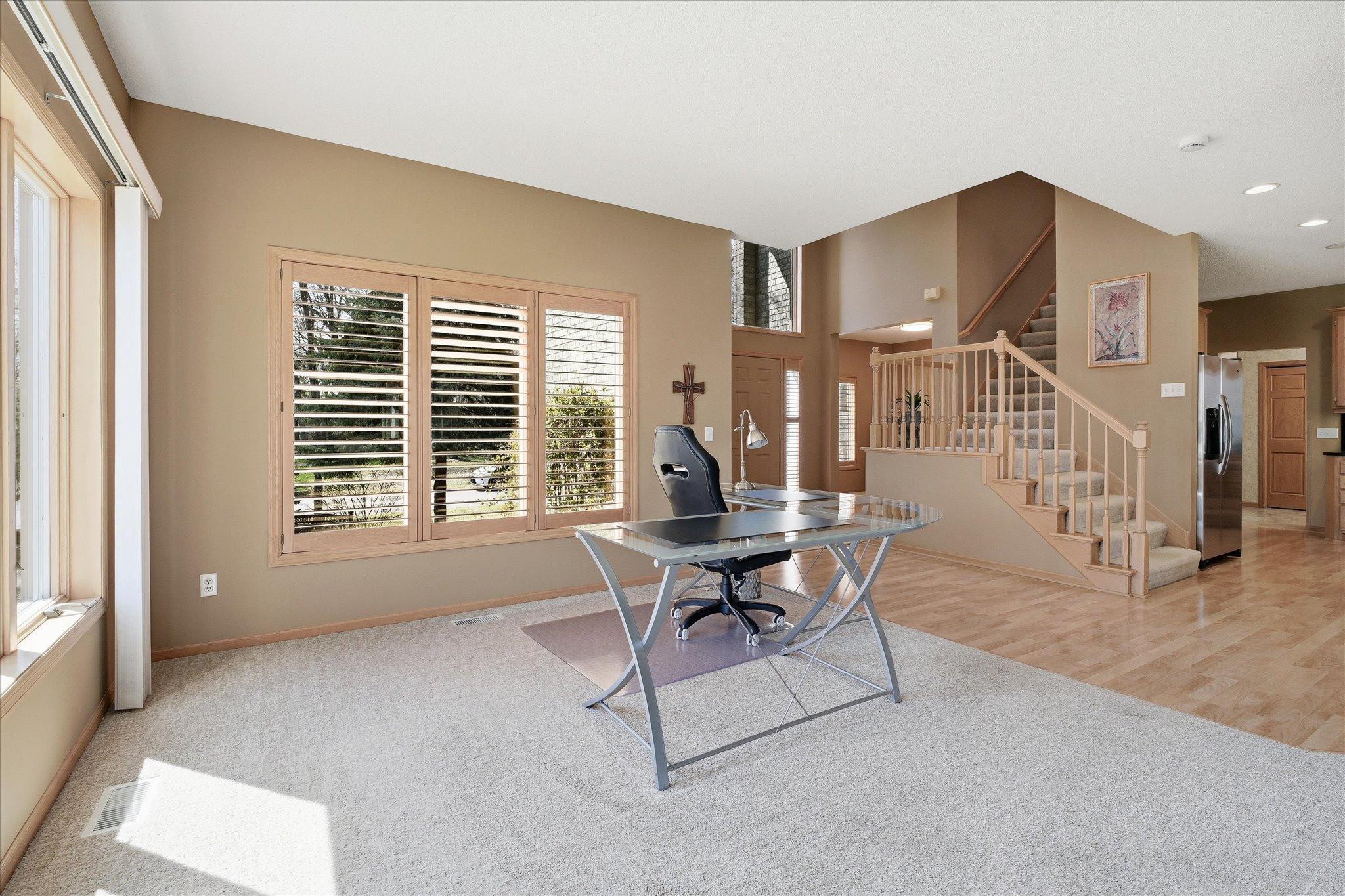 Flexible space Family Room with 9ft ceilings and newer neutral carpet. Open staircase to front entry and upper level