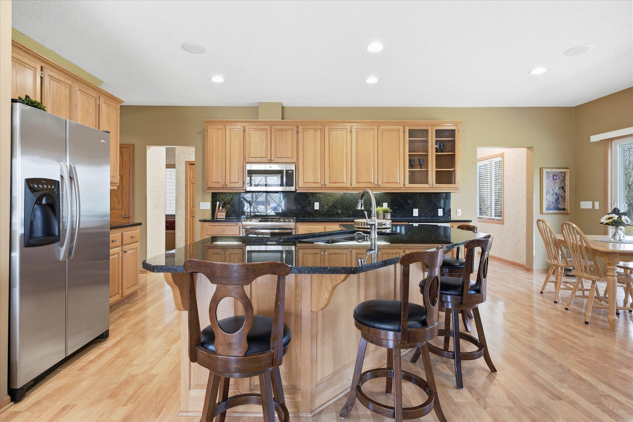 Updated Kitchen features: updated granite counter tops including huge flat center island, granite backsplash, ss appliances (gas range w/microwave vent to outside), recessed lights