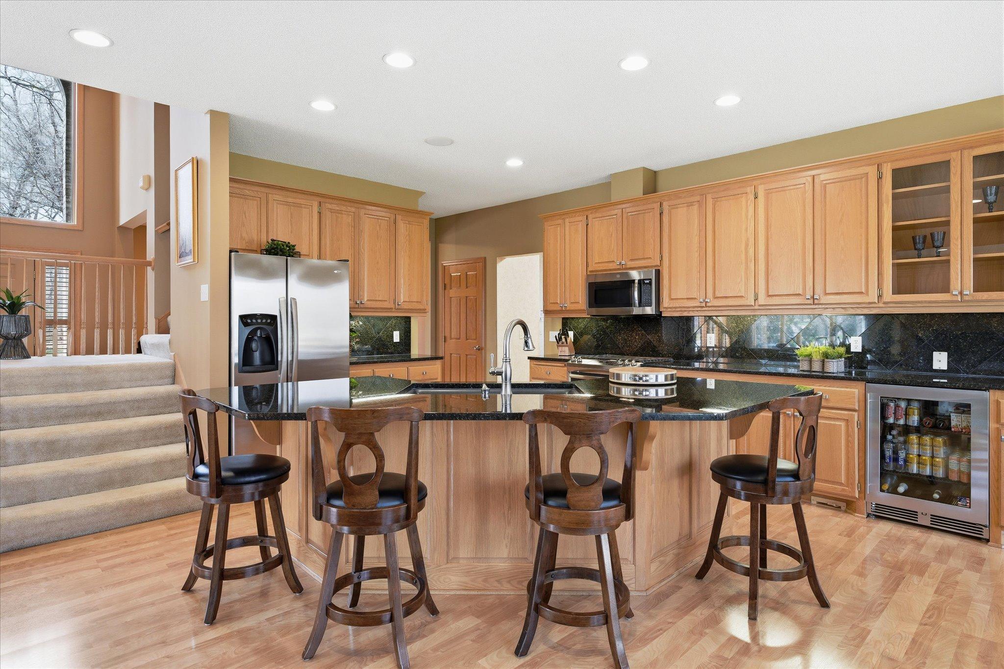 Updated Kitchen features: updated granite counter tops including huge flat center island, granite backsplash, ss appliances (gas range w/microwave vent to outside), recessed lights