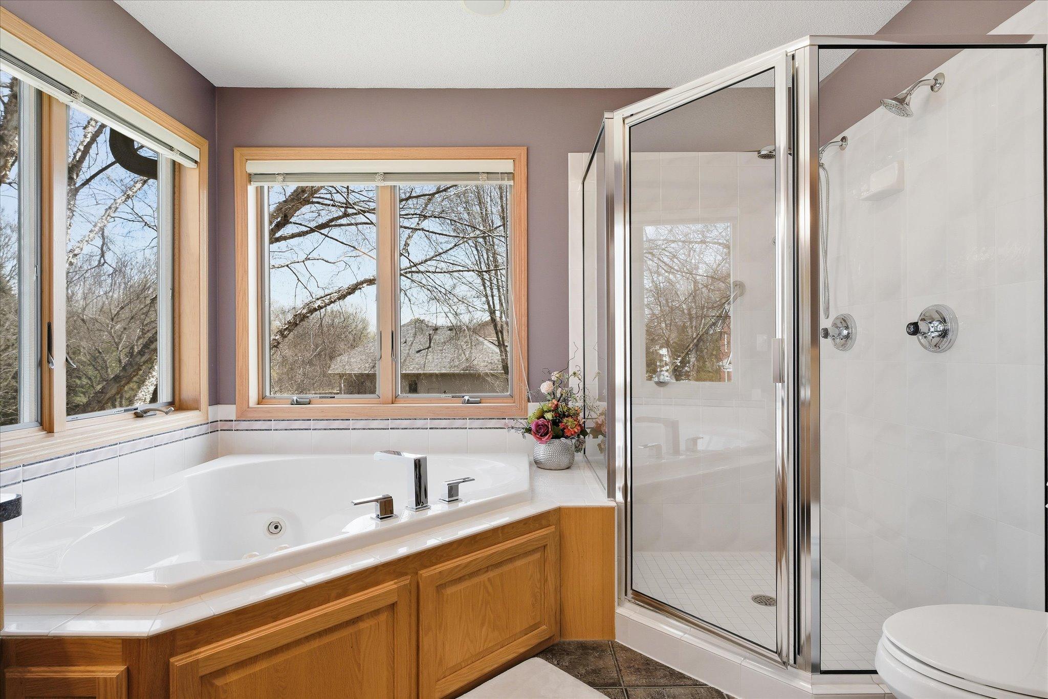 Primary Bathrm On-Suite features: dual sink vanity, corner whirlpool tub w/new faucet, tile floors (partially heated) and full shower w/glass door