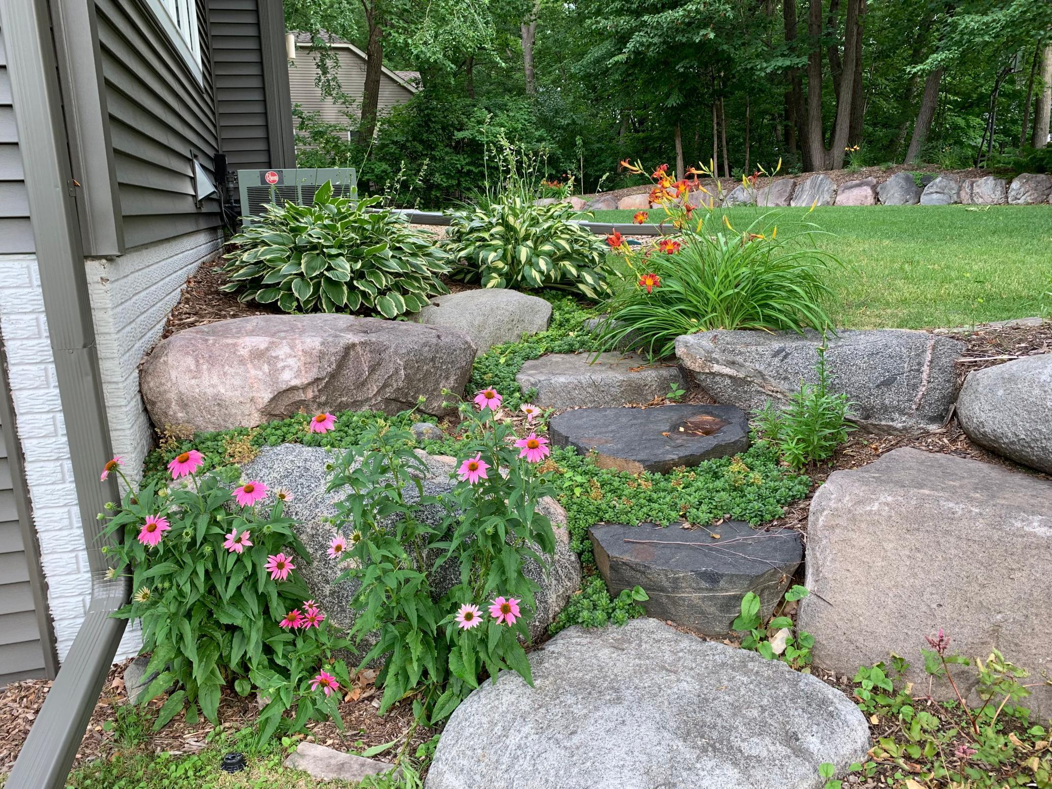 Beautiful colorful perennial plantings and boulder steps landscaping