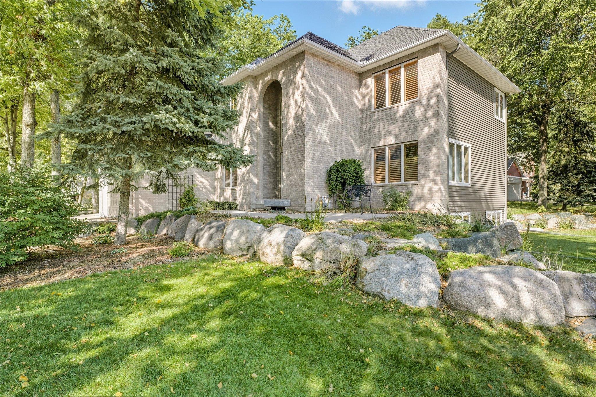 Beautiful landscaping includes: three landscaped berms, custom boulder retaining walls w/boulder steps, stone edging, numerous colorful perennial flowers/plants and mature trees throughout the entire front + back yards