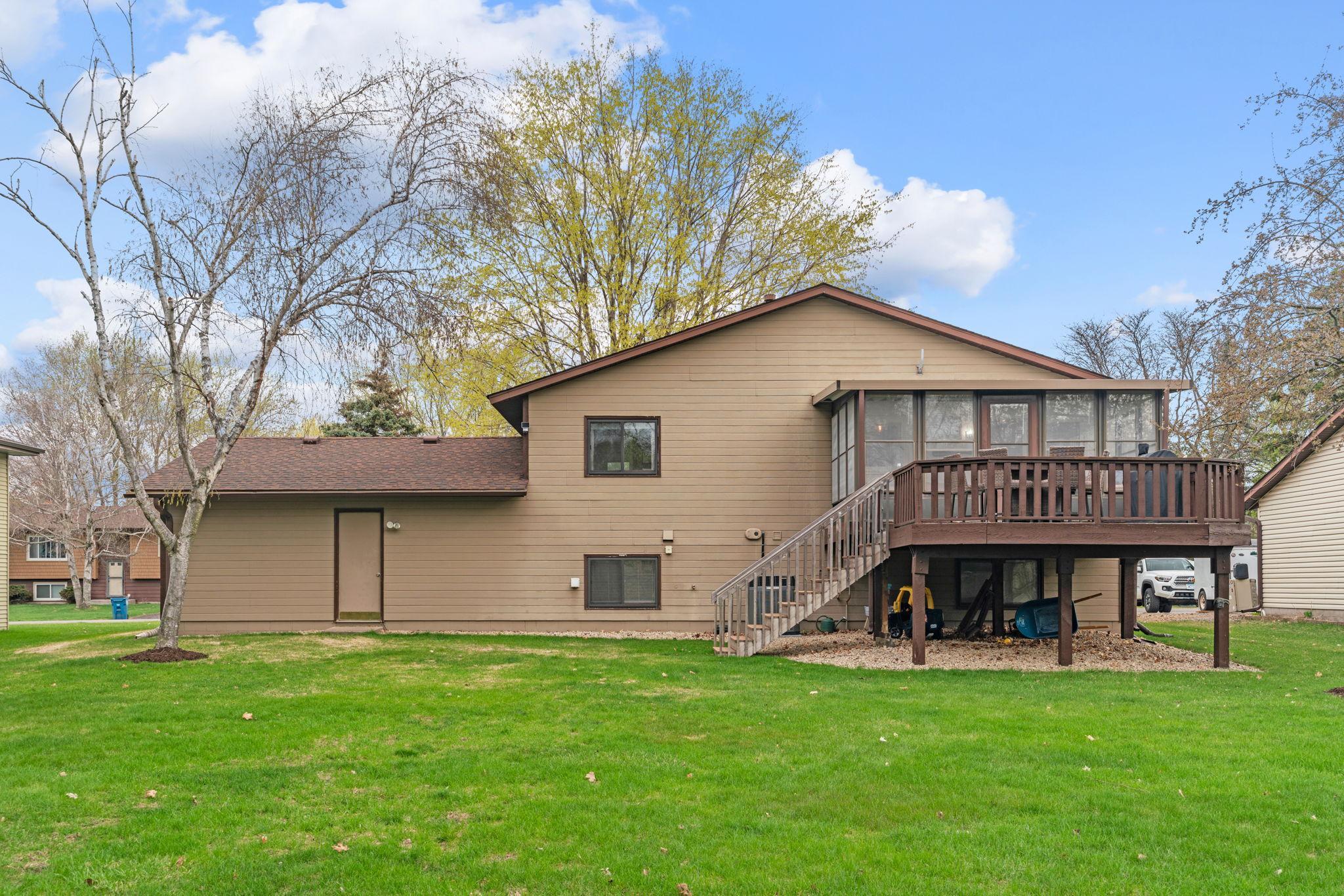 Exterior of Home with Expansive Yard, Deck, and Mature Trees
