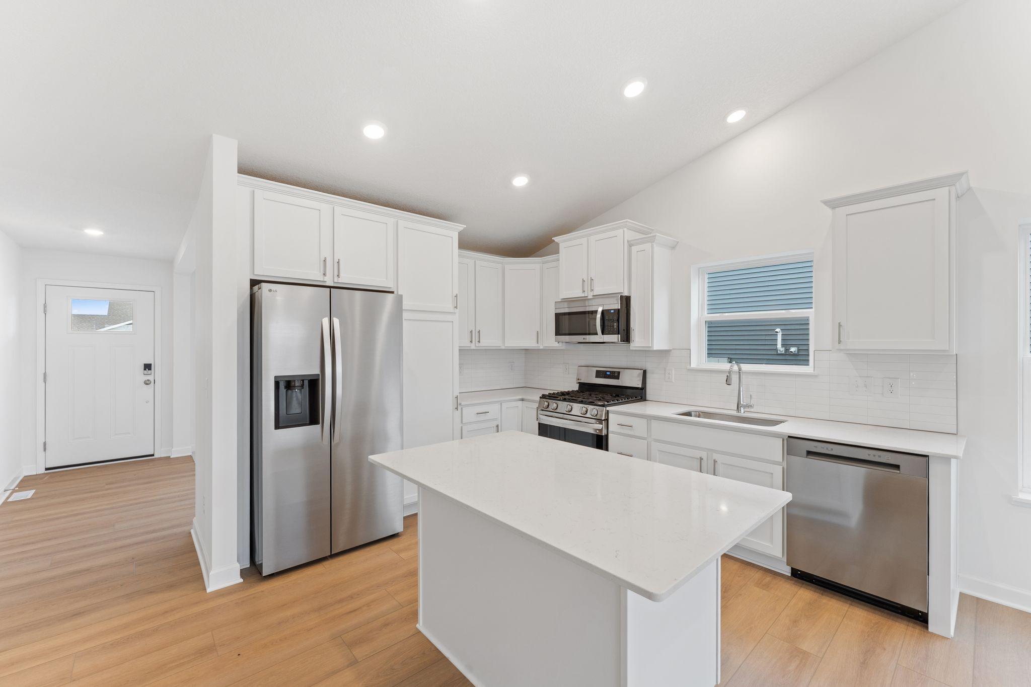 The chef-inspired kitchen showcases an elevated design, equipped with new cutting-edge appliances and a center island that adds bar-style seating.