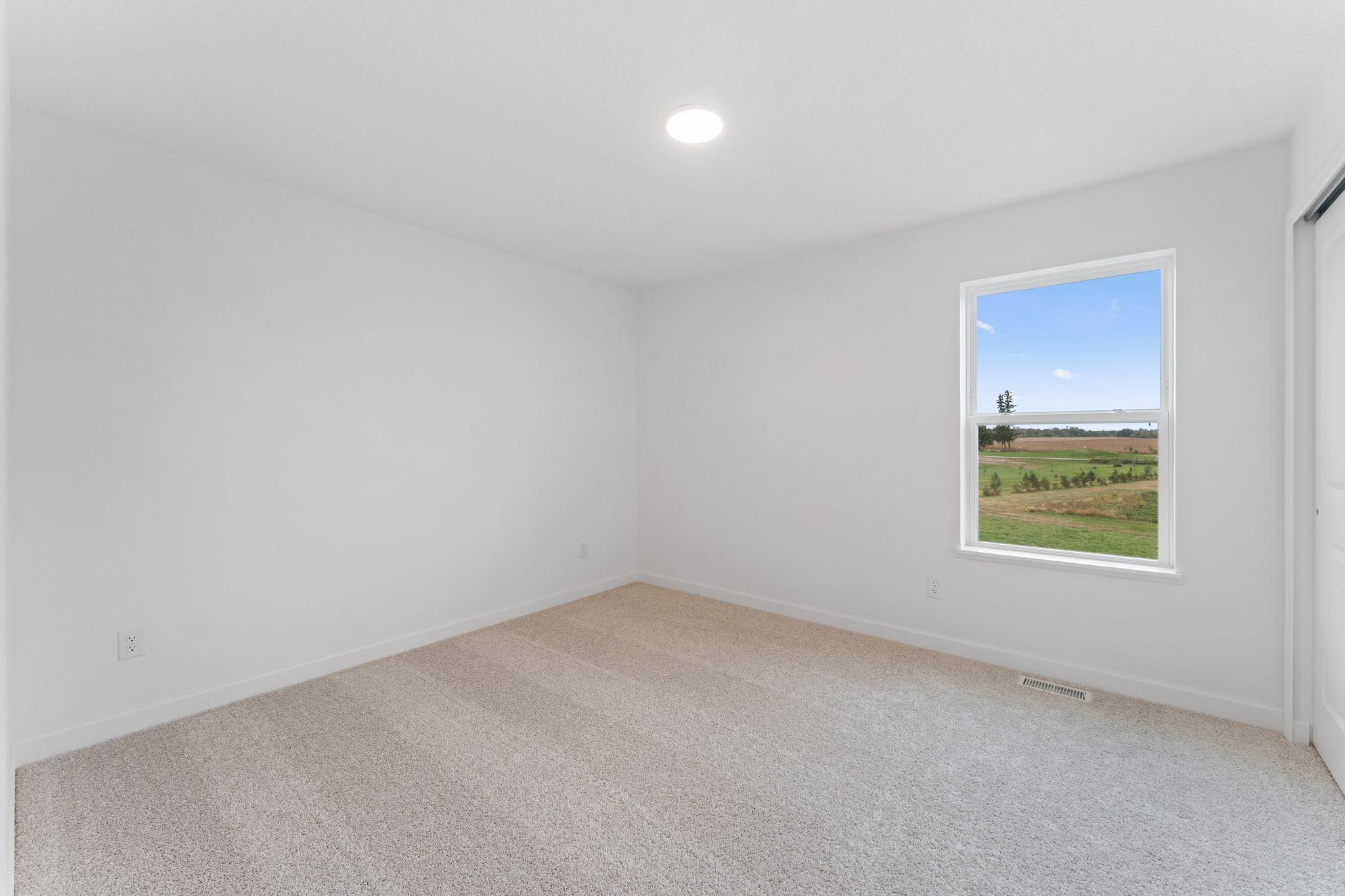 Two secondary bedrooms are located in a rear corner of the home, providing peaceful havens.