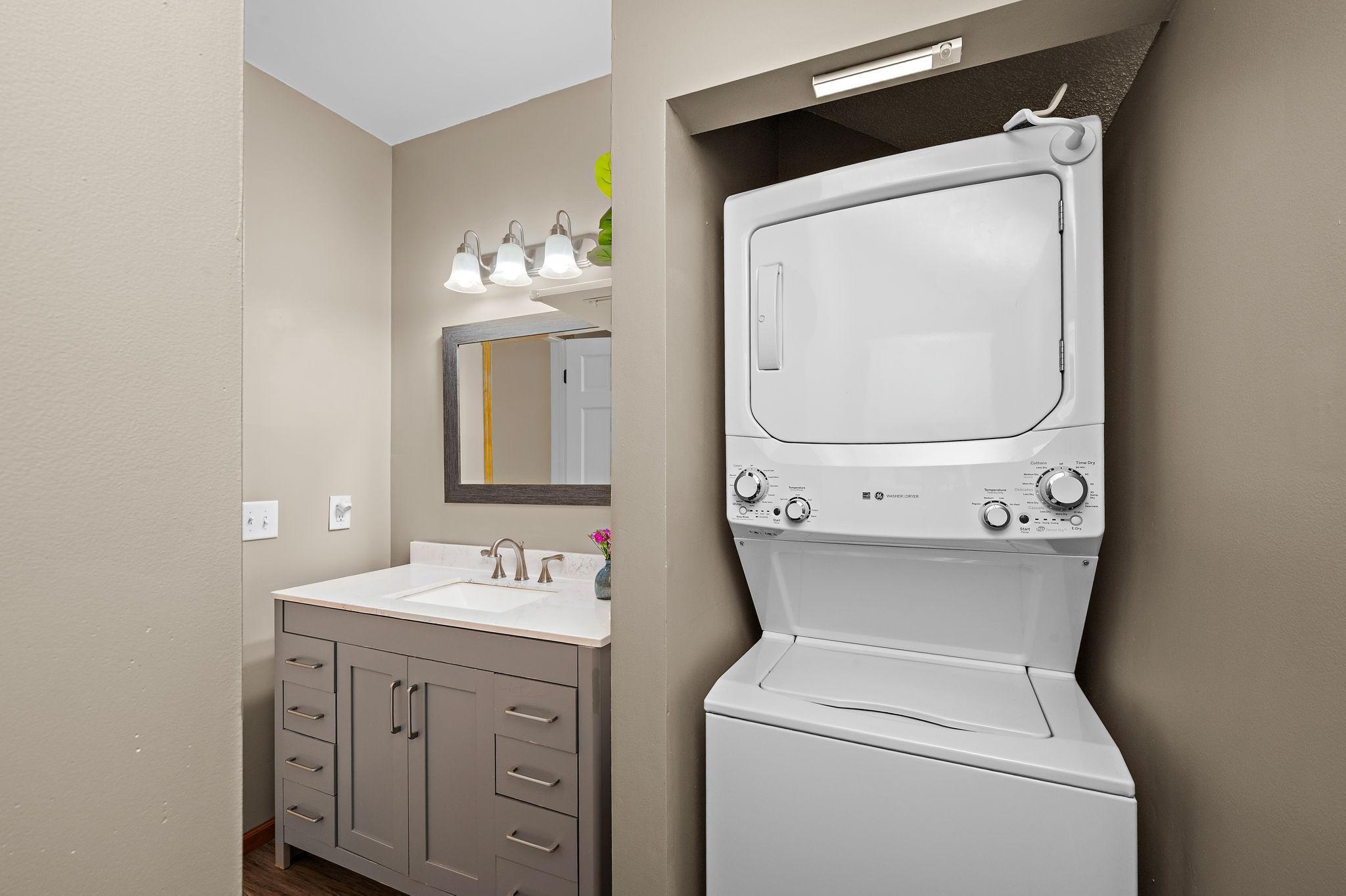 Stacked Washer and Dryer conveniently located within the full bath next to the primary bedroom.