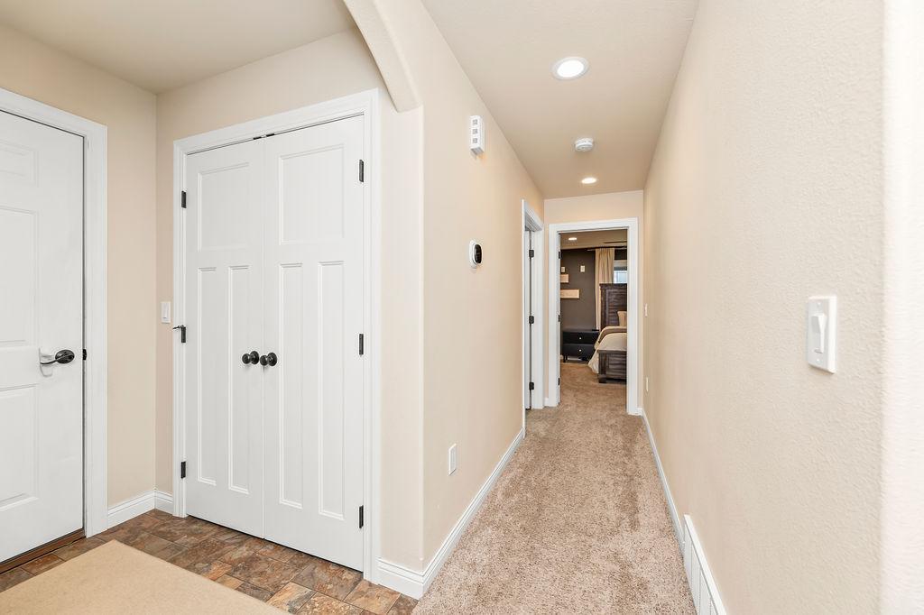 Hallway from Garage entry, offers recessed lighting, arched opening, storage/coat closet