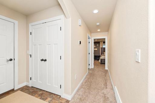 Hallway from Garage entry, offers recessed lighting, arched opening, storage/coat closet
