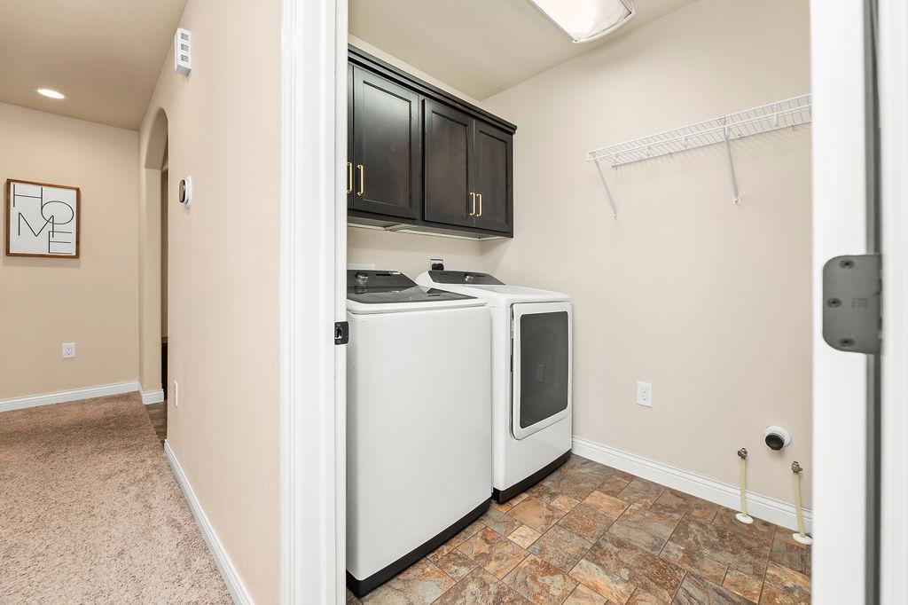 Main floor laundry room with hanging space & storage cabinets