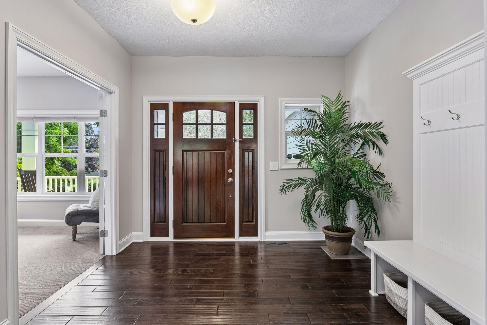Entry foyer with hardwood flooring, glass-panel front door with office sitting off the front of home
