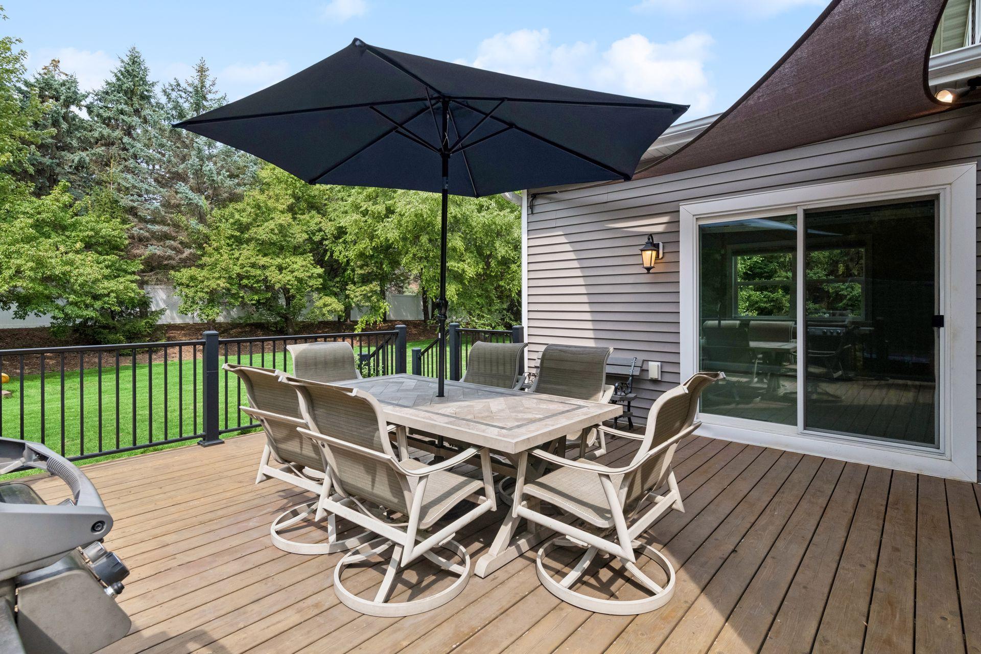 Raised deck with metal railing and sliding door access to sunroom