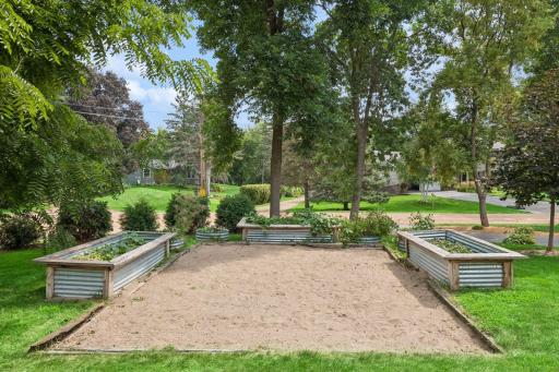 Raised garden beds with gravel surround and mature tree canopy