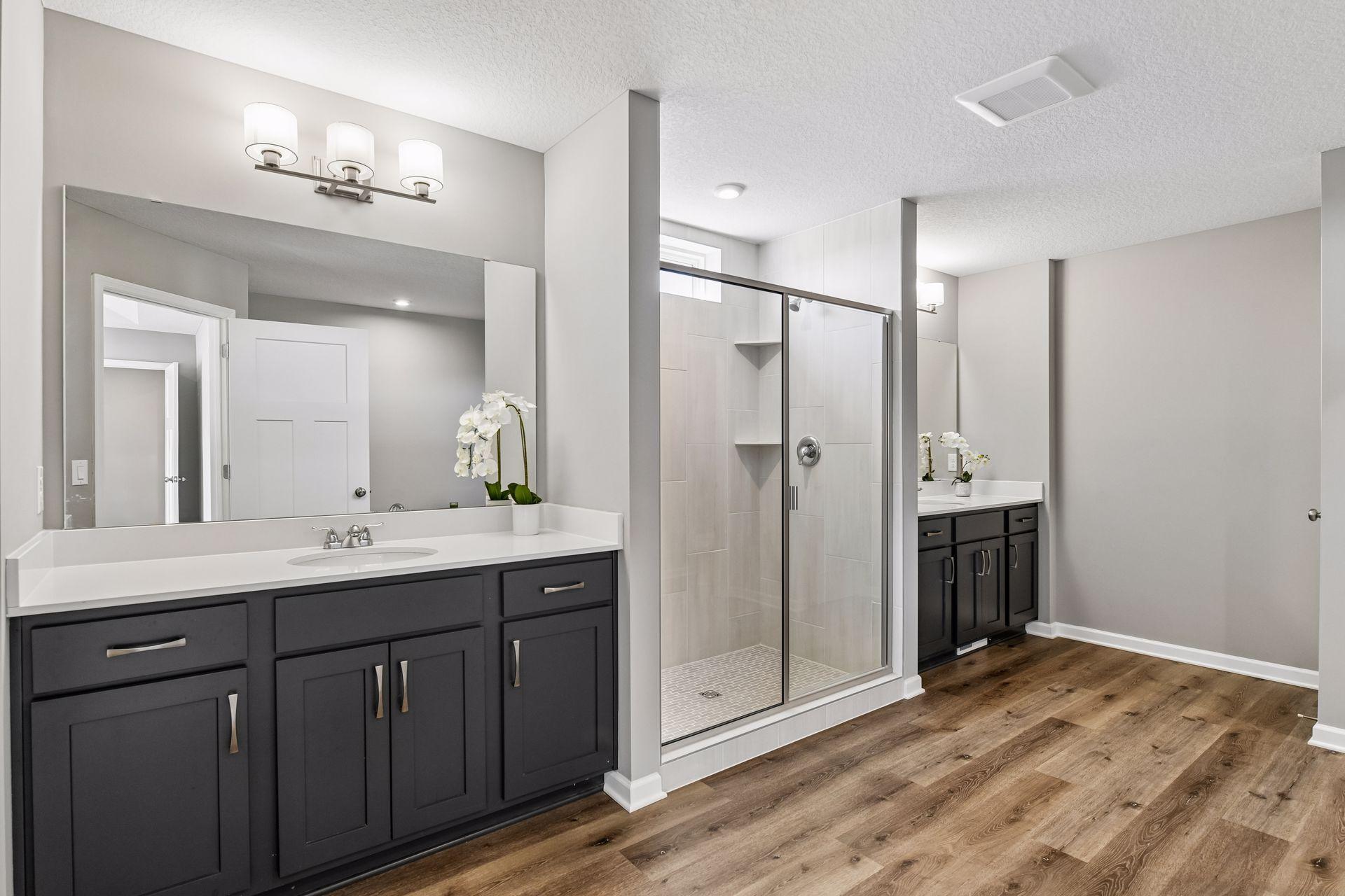 Primary bathroom includes dual vanities, tiled walk in shower, soaking tub and large walk in closet