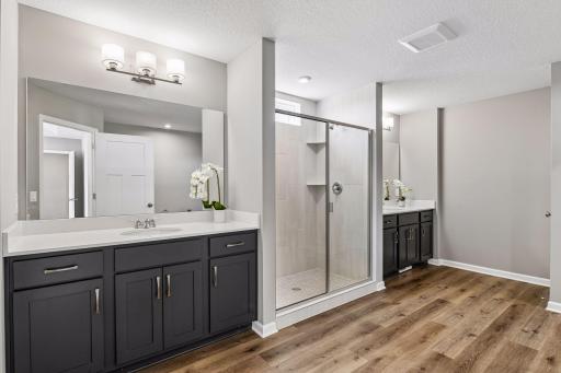 Primary bathroom includes dual vanities, tiled walk in shower, soaking tub and large walk in closet