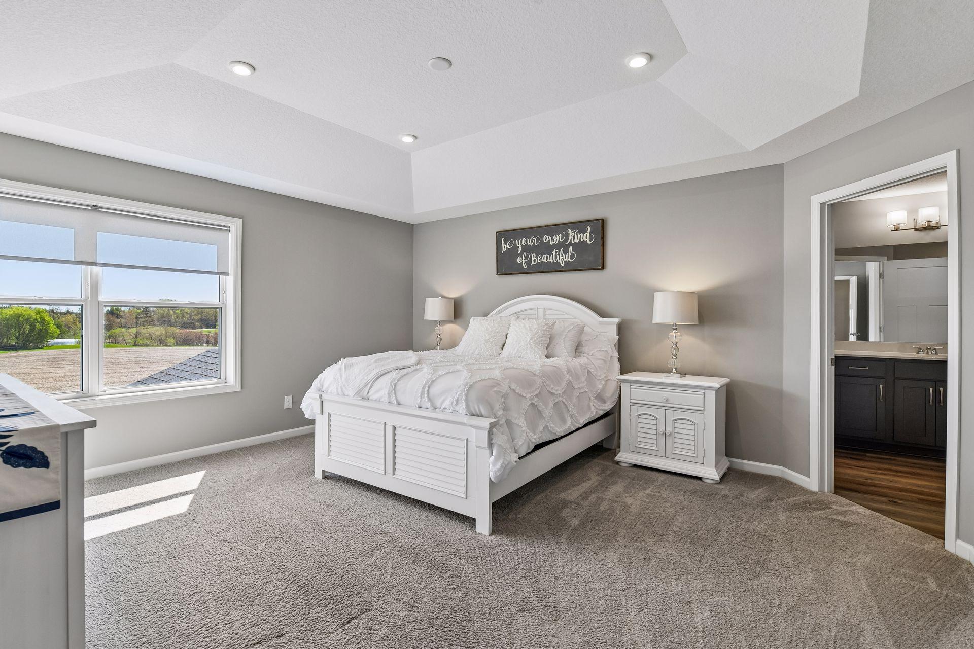 Primary bedroom off the back of the home includes tray ceiling and private east facing views