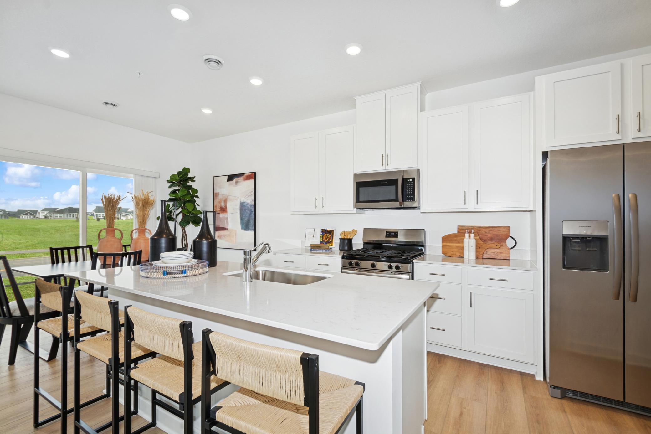 (Photo of model home, features will vary) A subway tile backsplash atop the 5-burner gas cooktop with an overhead microwave meets style with functionality