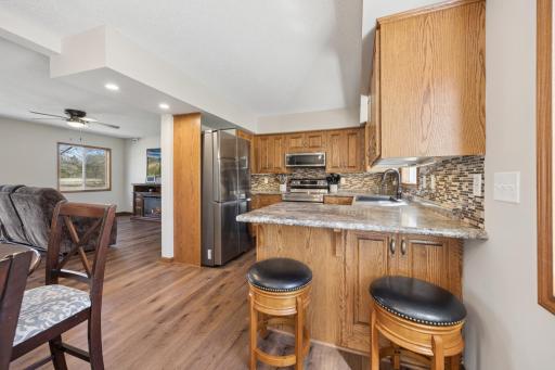 Kitchen area offers quality solid oak cabinetry, a peninsula island with added counter seating, backsplash, and SS appliances!