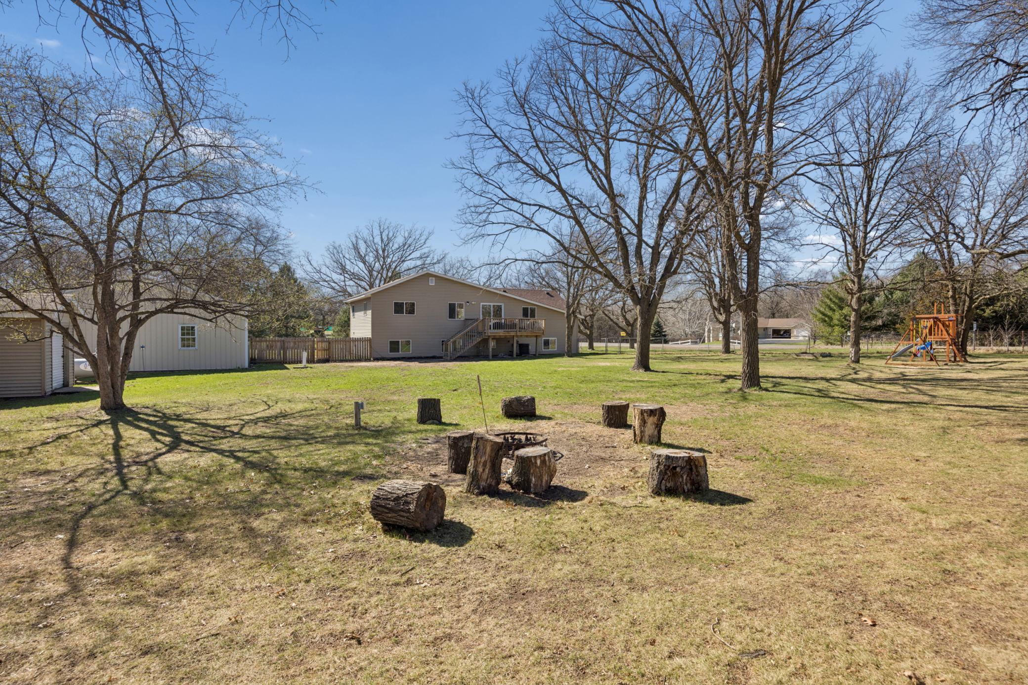 Backyard view complete with firepit area! Wonderful flat space.. Imagine playing bags here !