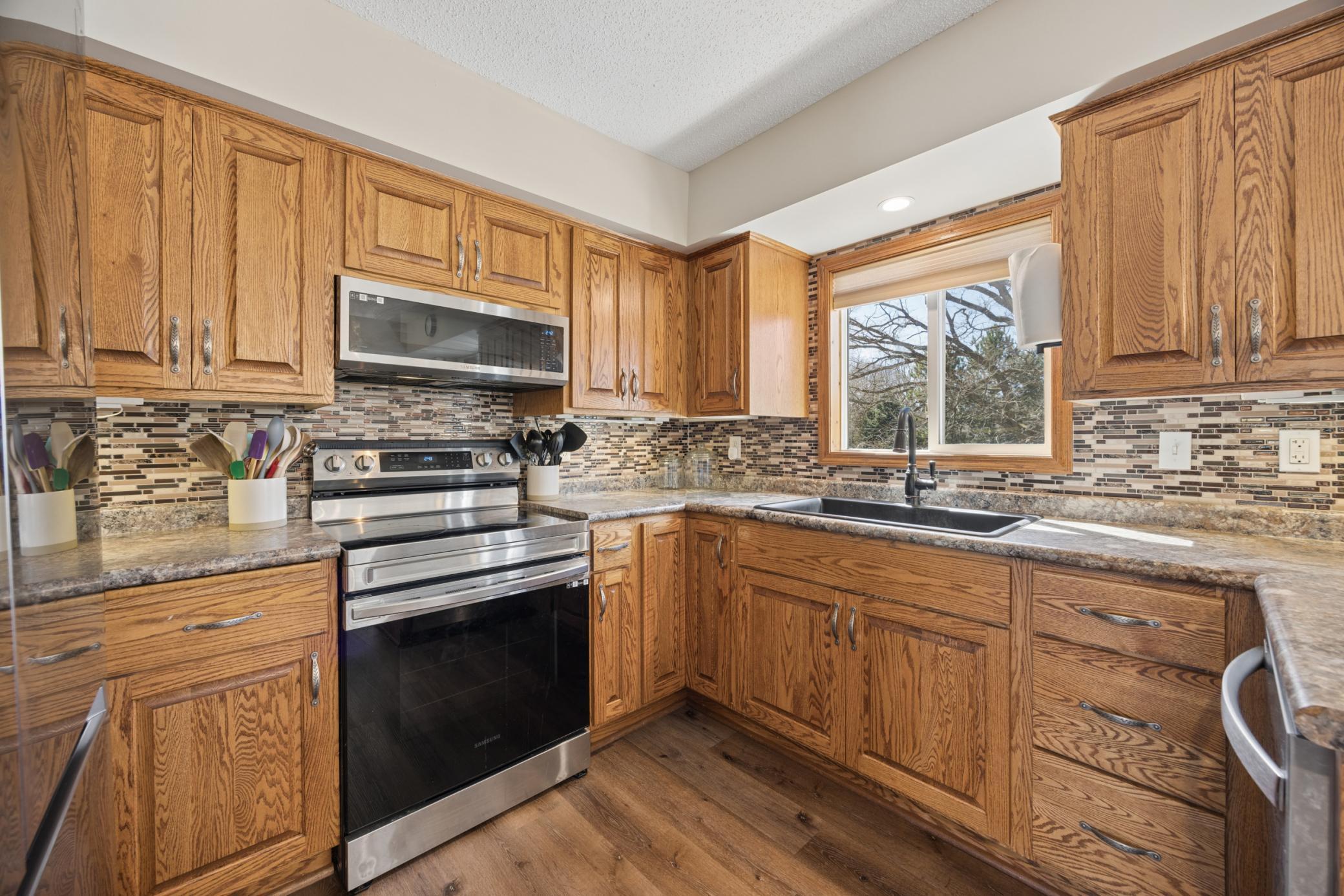 Imagine cooking here every day! Large sink space with kitchen window overlooking the front wooded yard!