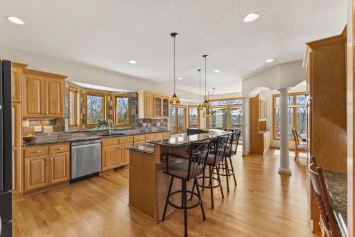 Spacious open kitchen with granite counters and stone backsplash
