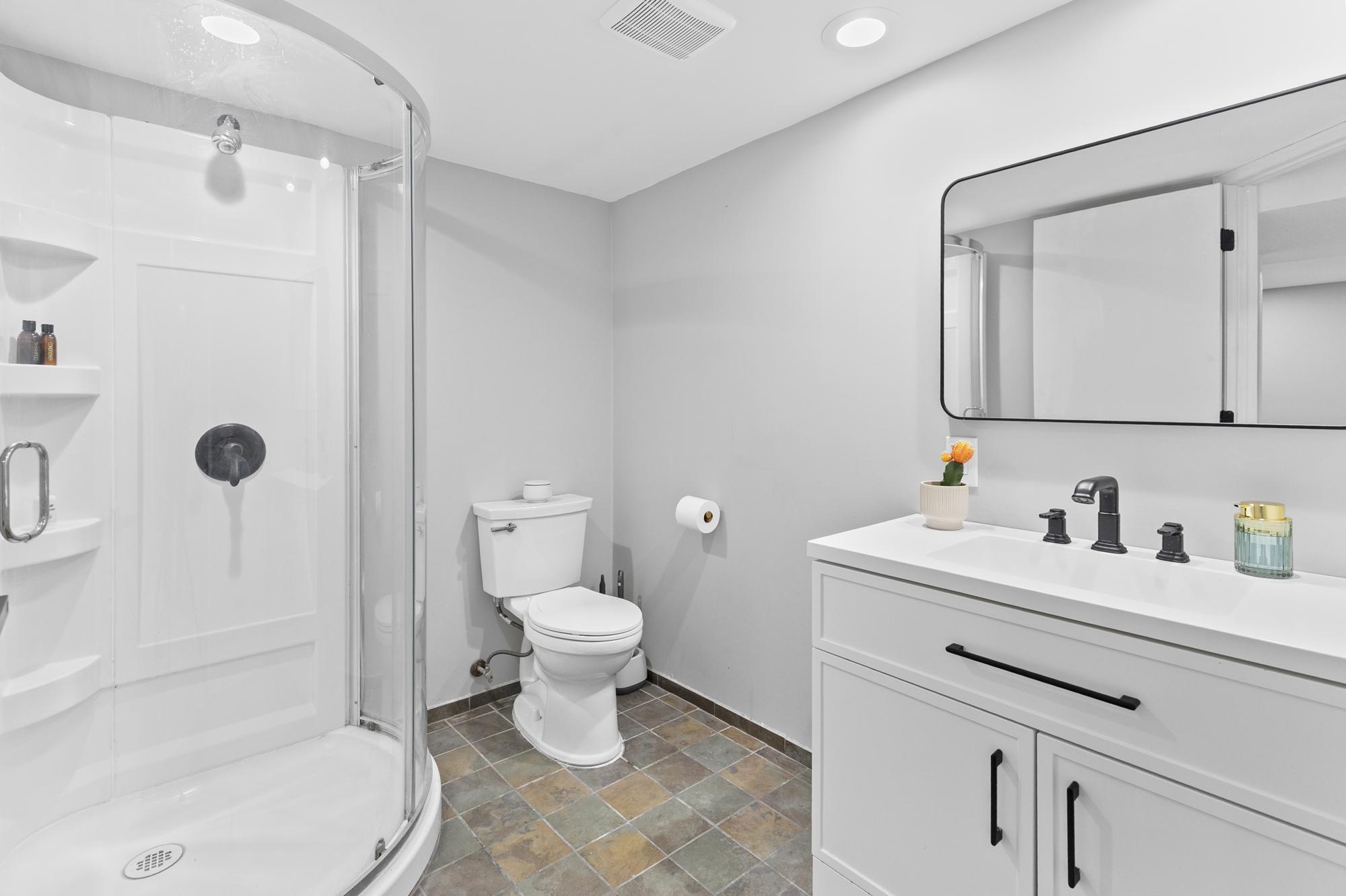 The updated lower level three-quarter bath boasts a sleek new vanity and a beautiful, convenient walk-in shower.