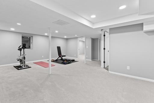 The spacious lower level is currently set up as a home gym but offers incredible potential. With an egress window already installed nearby, it is a great candidate for a future bedroom addition.