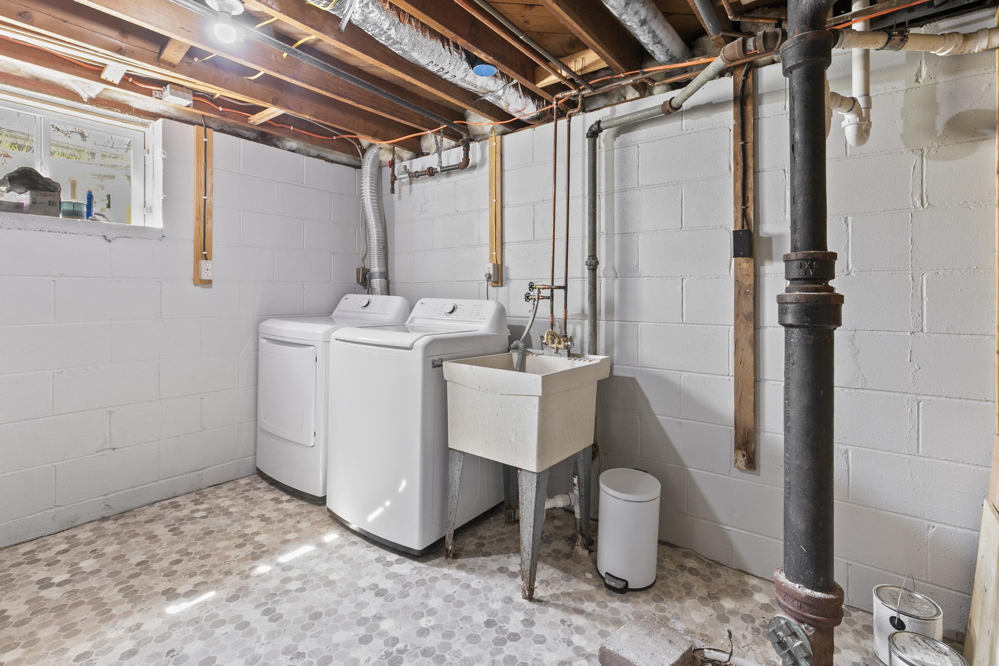 The clean and organized utility room features a brand new furnace, a new washer and dryer set, and a handy utility sink.