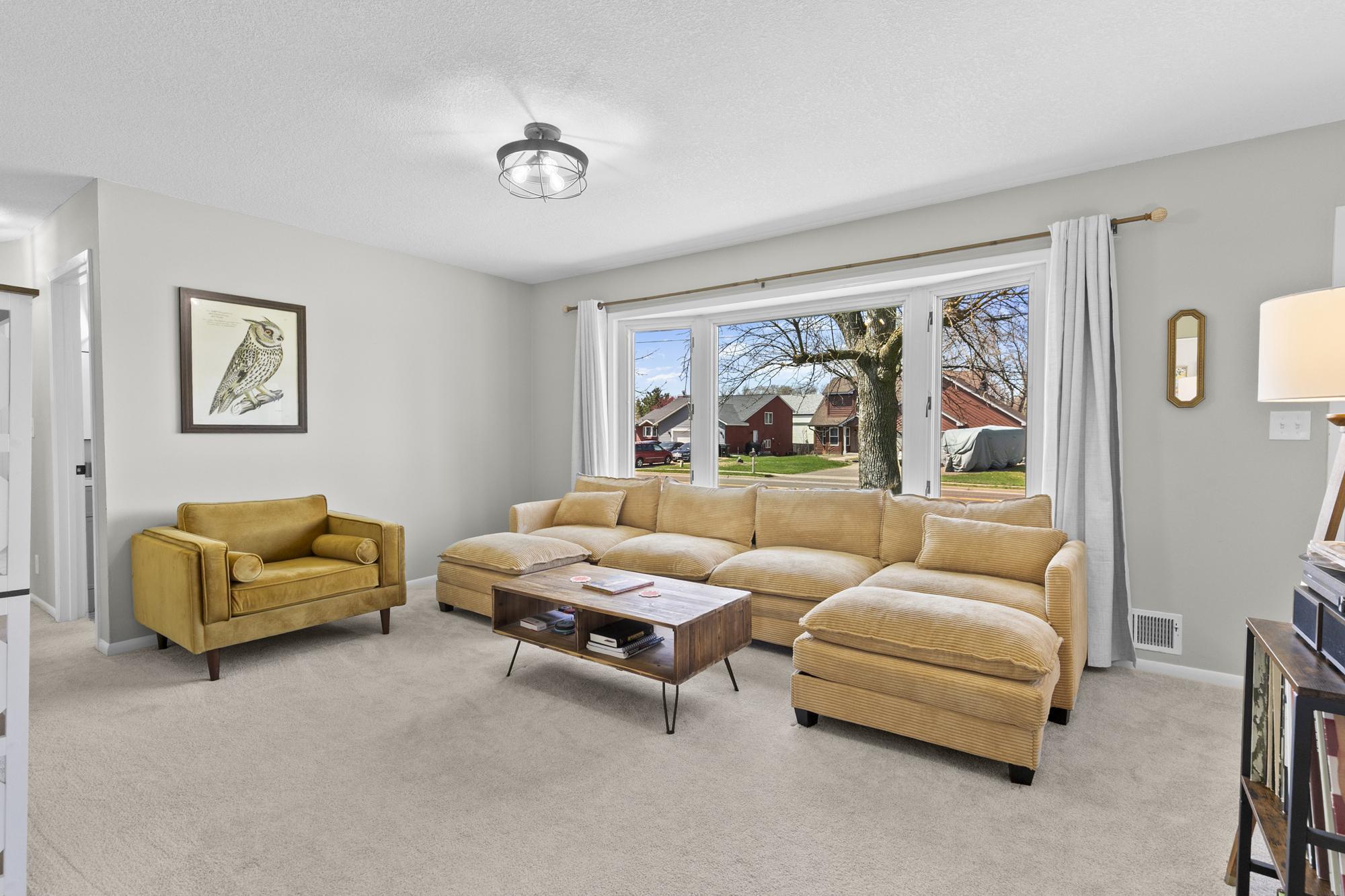 A massive picture window floods this comfortable living room with incredible natural light.