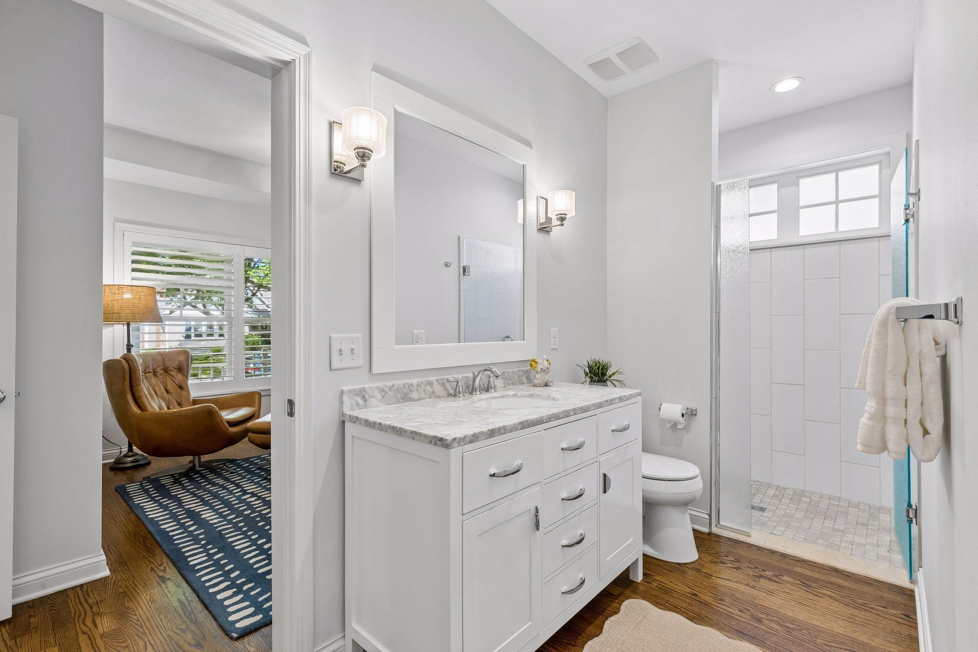 Adjacent bathroom with step-in tile shower, and access to both the living room and main floor bedroom/office.