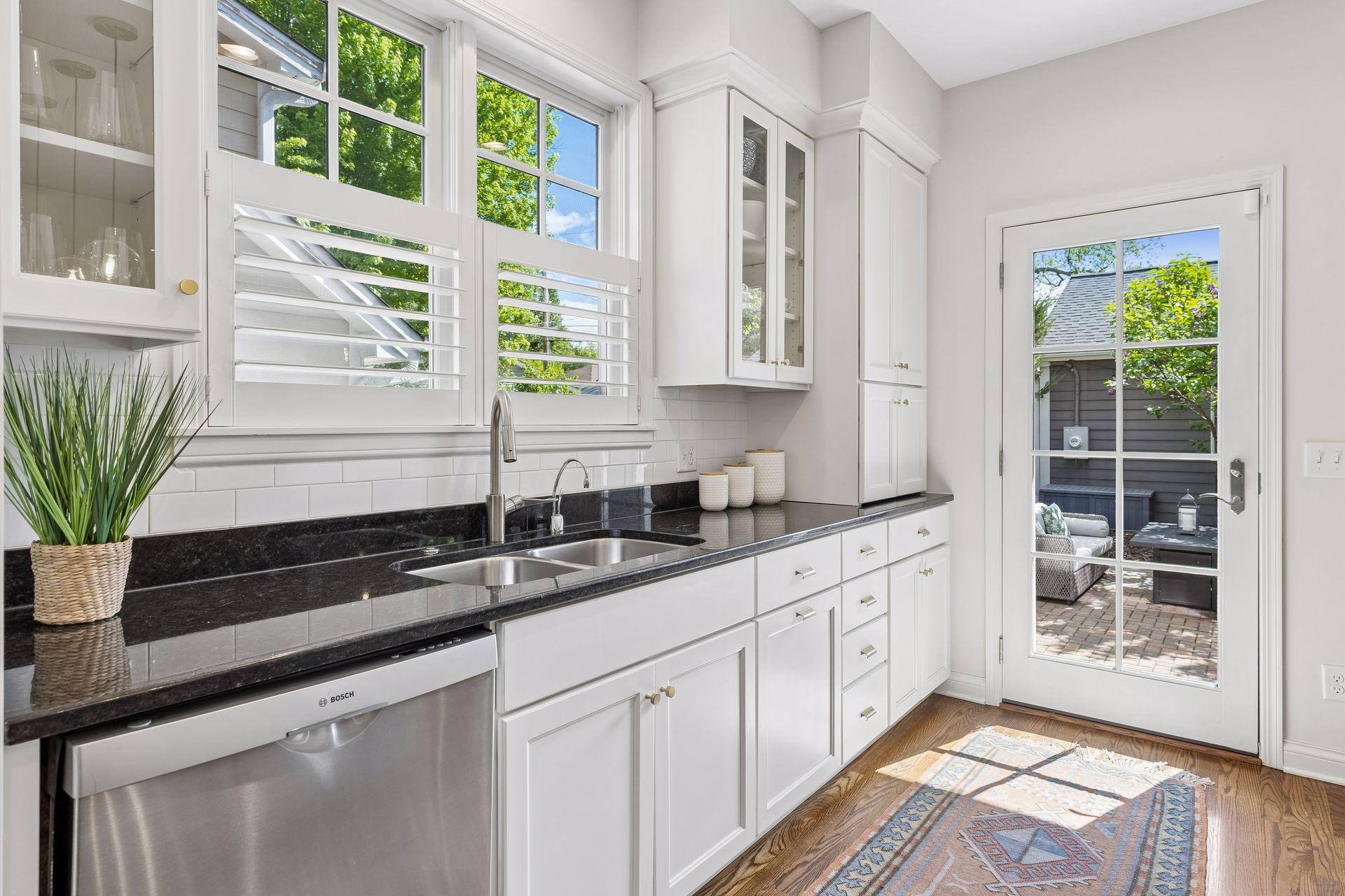 Granite countertops and large kitchen window over the sink.
