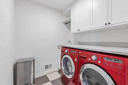 Convenient upstairs laundry room, with custom cabinets by California Closets.