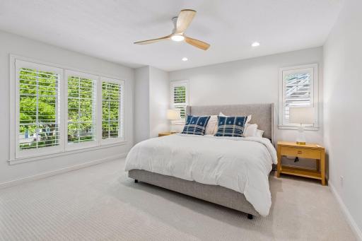 Primary suite upstairs, with custom wood shutters.