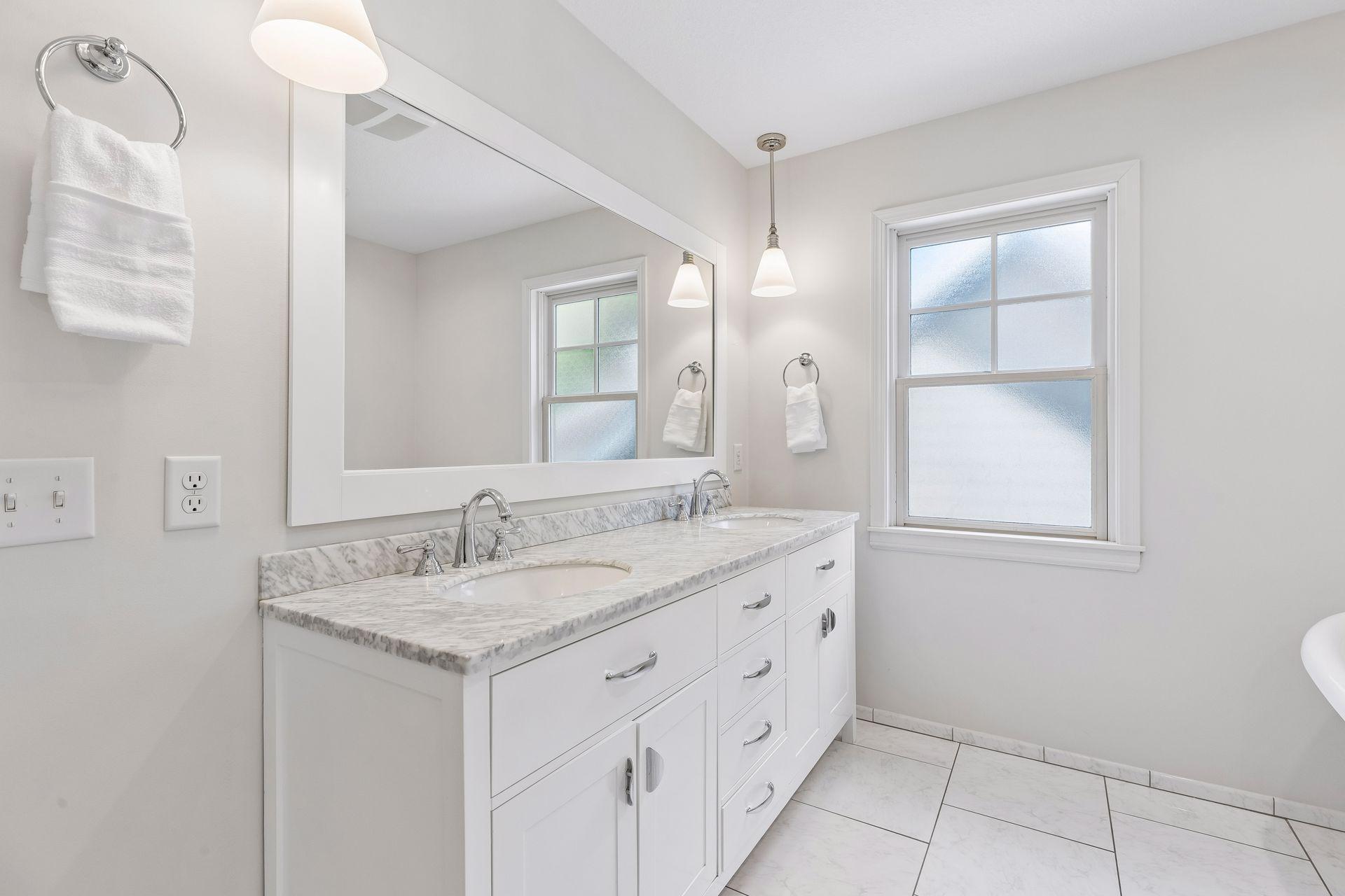 Primary ensuite bath with marble top double-sink vanity