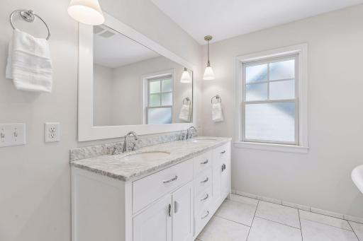 Primary ensuite bath with marble top double-sink vanity