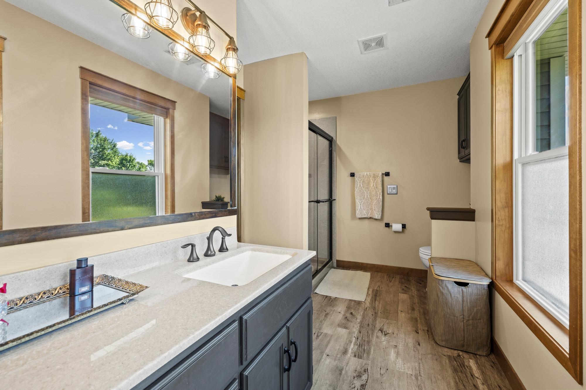 Primary bath shower has corian, grout free, stone slabs