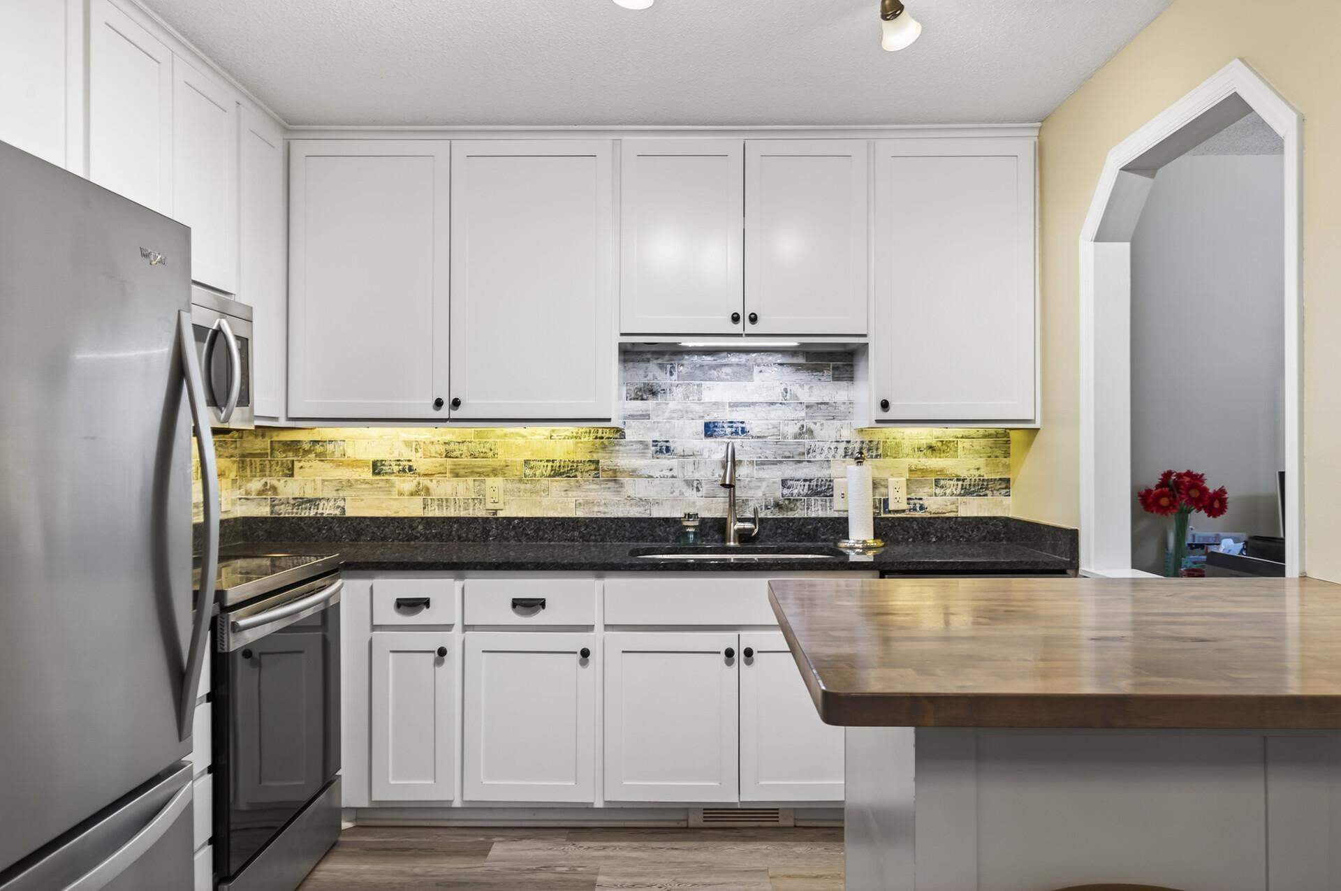 Beautiful kitchen with White enamel cabinetry with granite counter tops, undermount cabinet lighting.