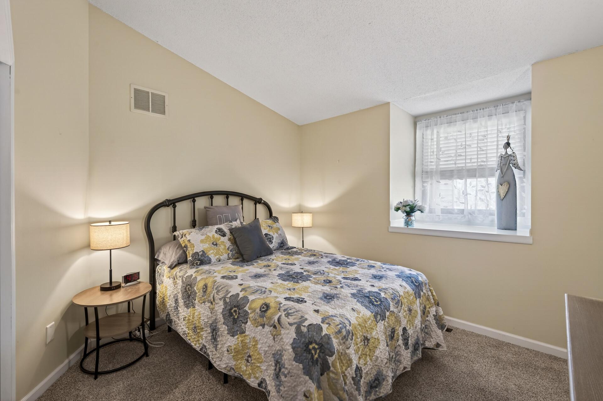 Vaulted second bedroom with oversize windows.